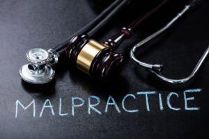 stethoscope and gavel over words that say "malpractice"