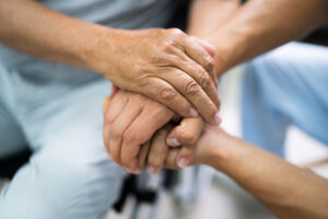 Elderly hand holding younger hand