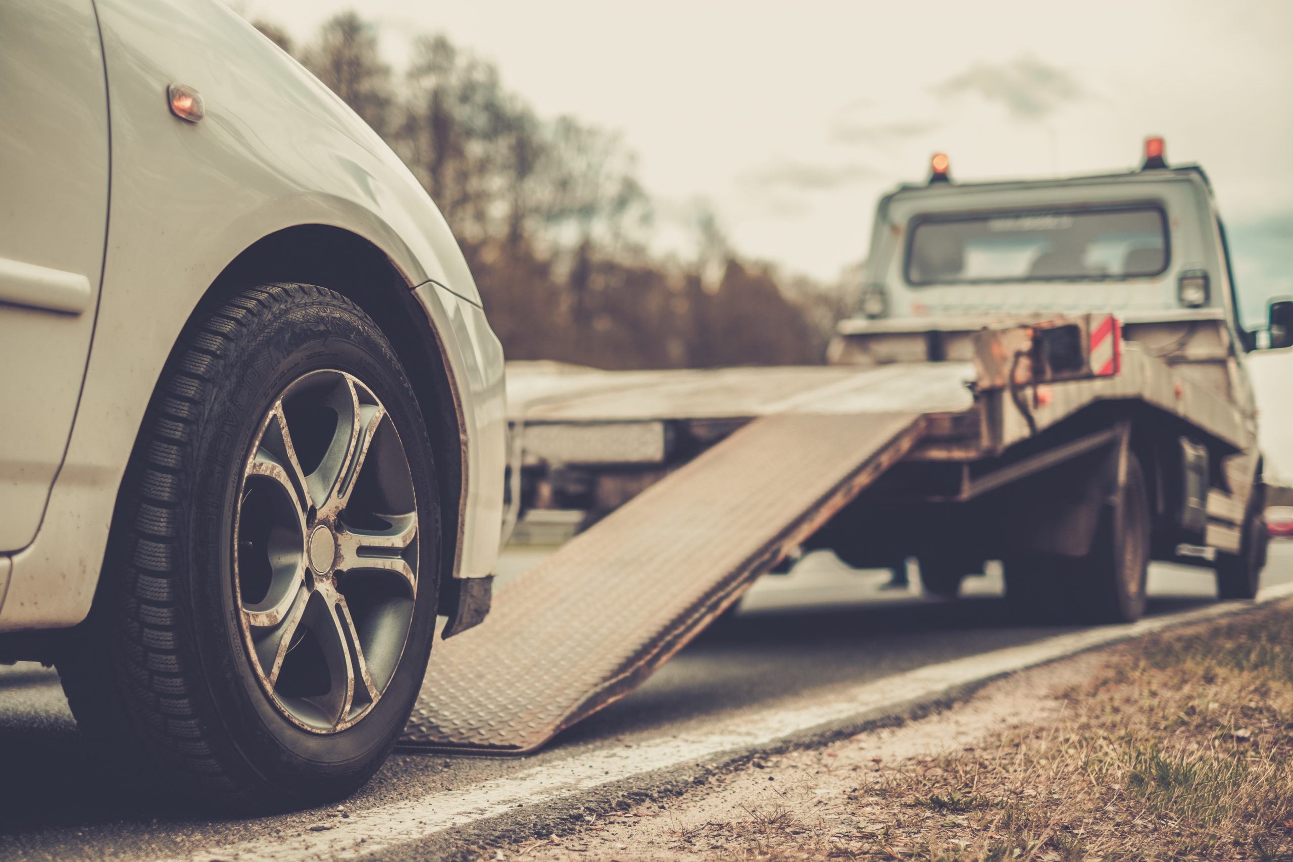 Emotional Distress After A Truck Accident - Loading broken car on a tow truck on a roadside